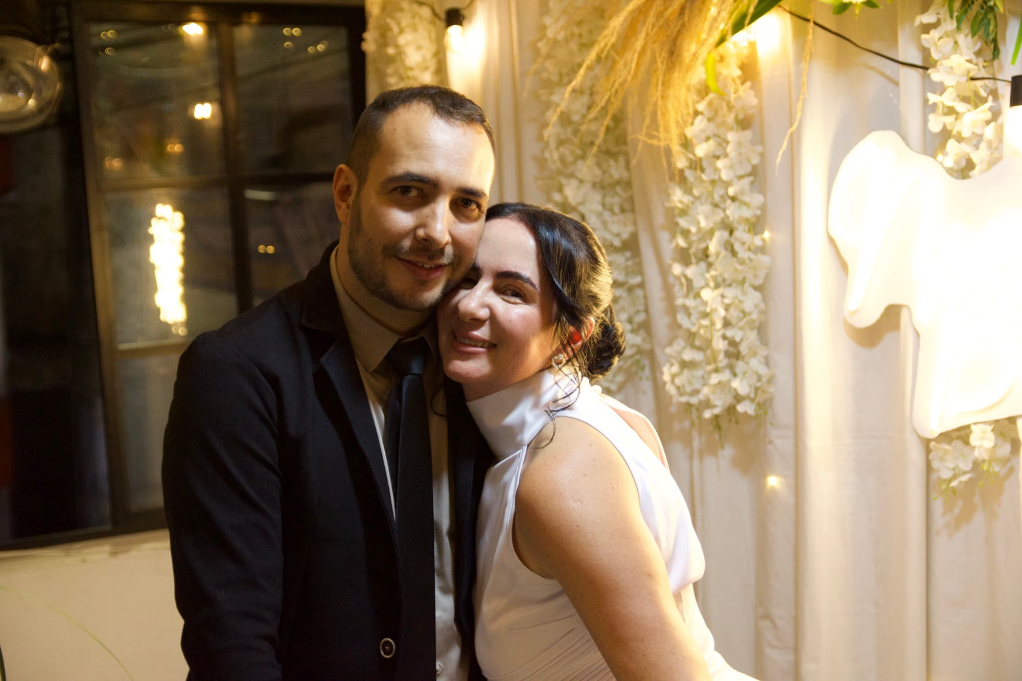 Retrato de los novios juntos, ella apoyada en su hombro, ambos sonriendo
